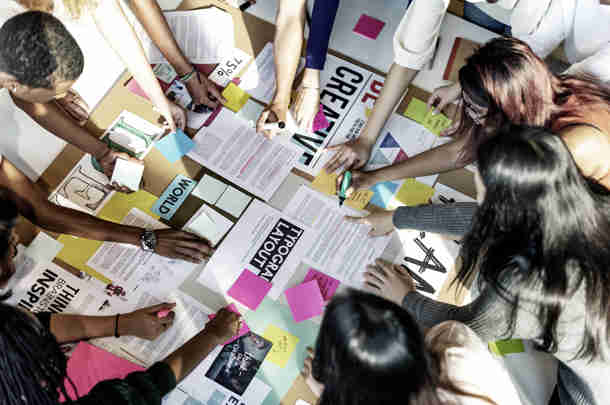 Groep collega's brainstormt met post-its over positionering